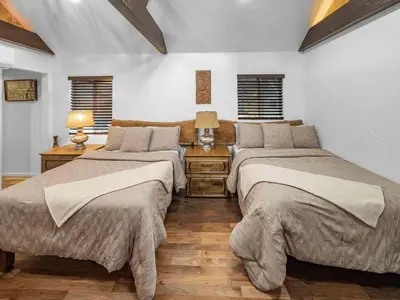 two beds in a room with two tables and two lamps at Mountain Deer Cabin W Foosball & Fenced Backyard in Big Bear City