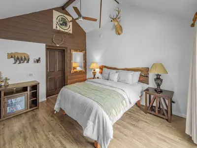 a bedroom with a large bed and a dresser with two lamps at Mountain Deer Cabin W Foosball & Fenced Backyard in Big Bear City