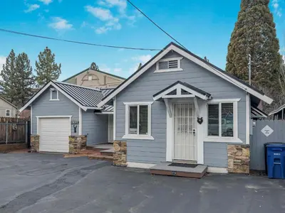a grey house with a driveway in front of it at Mountain Deer Cabin W Foosball & Fenced Backyard in Big Bear City