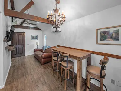 a living room with a dining room table and a couch at Mountain Deer Cabin W Foosball & Fenced Backyard in Big Bear City