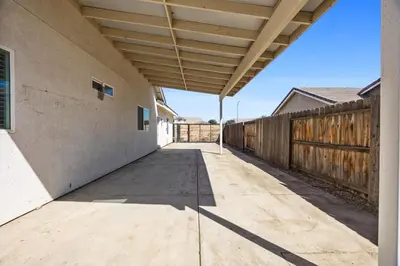 a walkway leading to a building with a wooden fence at Spacious Home with Private Pool in Bakersfield