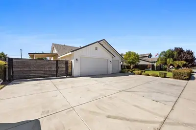 a house with a driveway with a white garage at Spacious Home with Private Pool in Bakersfield
