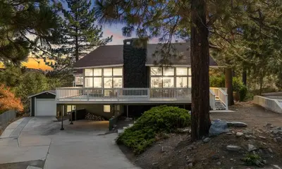 a large house with a balcony and a tree at Beautiful Wrightwood Chalet in Wrightwood