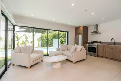 a living room with two couches and a table at Modern Poolside Paradise in Sherman Oaks