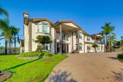 a large house with palm trees in front of it at Expansive Riverside Mansion! Luxe, Family Friendly in Riverside