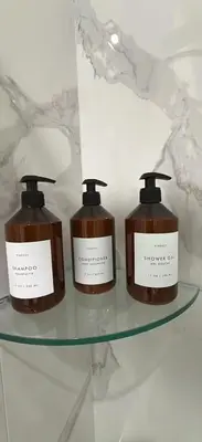 two bottles of soap sitting on a glass shelf at Luxurious Pasadena Home w Parking & Near Old Town in Pasadena