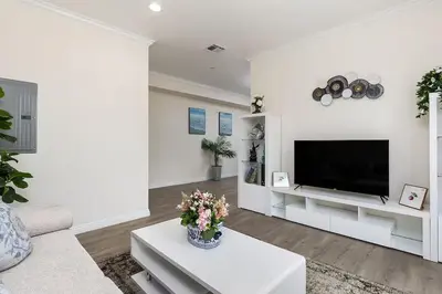 a white living room with a flat screen tv at Luxurious Pasadena Home w Parking & Near Old Town in Pasadena