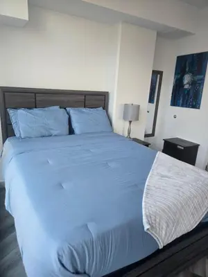 a bedroom with a large bed with blue sheets at 2 Bedroom with City Views in Los Angeles