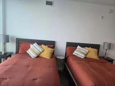 a bedroom with two beds with orange sheets and pillows at 2 Bedroom with City Views in Los Angeles