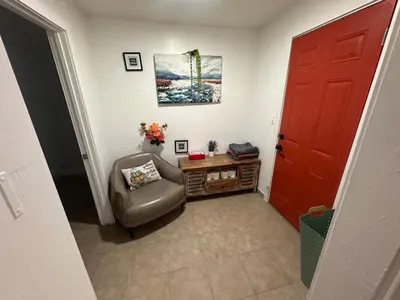 a living room with a red door and a chair at Desert Oasis Retreat in Barstow in Barstow