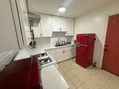 a kitchen with a red refrigerator and white cabinets at Desert Oasis Retreat in Barstow in Barstow