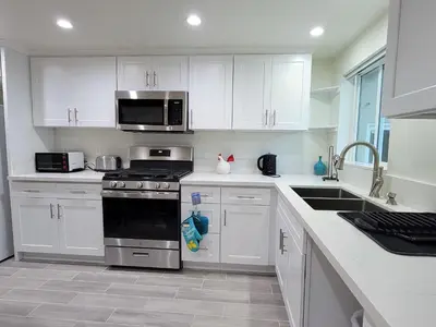 a kitchen with white cabinets and a stove top oven at Modern 2BR Guest Suite w En-Suite Bathrooms 10 min to Rodeo Drive Near Kaiser and Cedars hospitals in Los Angeles