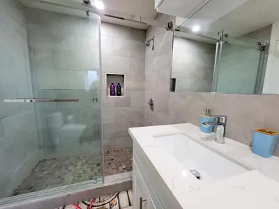 a bathroom with a shower and a sink and a mirror at Modern 2BR Guest Suite w En-Suite Bathrooms 10 min to Rodeo Drive Near Kaiser and Cedars hospitals in Los Angeles
