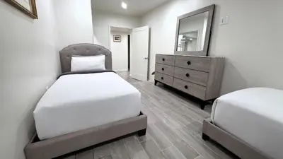 a bedroom with two beds and a dresser and a mirror at Modern 2BR Guest Suite w En-Suite Bathrooms 10 min to Rodeo Drive Near Kaiser and Cedars hospitals in Los Angeles