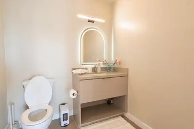 a bathroom with a toilet and a sink with a mirror at LA Hype Spot Sunset x Fairfax SkyView in Los Angeles