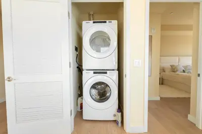 a washer and dryer in a room next to a door at LA Hype Spot Sunset x Fairfax SkyView in Los Angeles