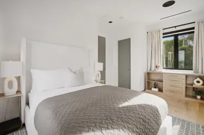 a white bedroom with a large bed and a window at Mulholland Edition in Beverly Hills