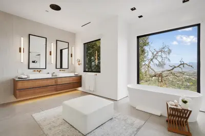 a bathroom with a tub and two sinks and a large window at Mulholland Edition in Beverly Hills