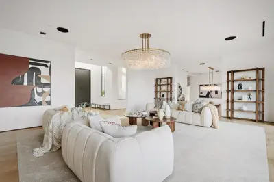 a living room with white furniture and a chandelier at Mulholland Edition in Beverly Hills