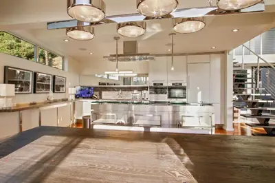 a large kitchen with stainless steel appliances and wooden floors at The Beverly Aura in Los Angeles