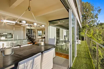 an open kitchen and dining area with a balcony with glass doors at The Beverly Aura in Los Angeles