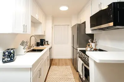 a white kitchen with white cabinets and appliances at Serene Urban Haven in Los Angeles