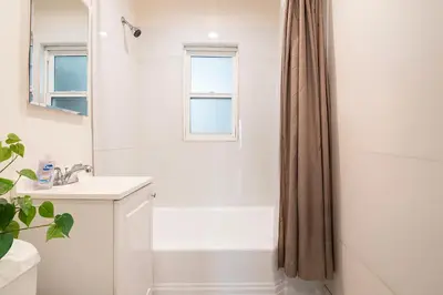 a white bathroom with a shower and a sink at Affordable 1BR apt near Beverly Hills in Los Angeles