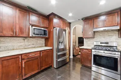 a kitchen with wooden cabinets and a stainless steel refrigerator at Peaceful Room in Riverside