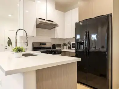 a kitchen with a black refrigerator and white cabinets at Holiday Home Modern Home by Interhome in Westminster