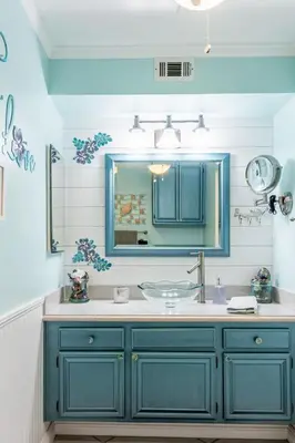 a blue bathroom with a sink and a mirror at Apartment Meerblick Eigentumswohnung gegenüber dem Strand by Interhome in Port Hueneme