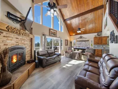 a living room with a couch and a fireplace at Holiday Home Haus mit Seeblick - Atemberaubende Aussicht - Haustierfreundlich by Interhome in Lake Arrowhead
