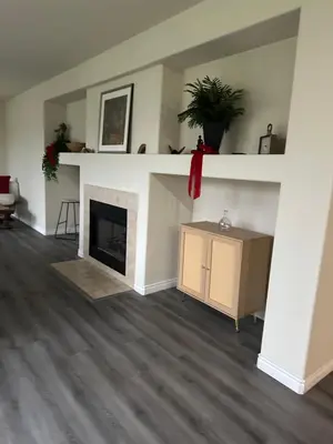 a living room with a fireplace and a shelf at Big bedroom shared bathroom in Fontana