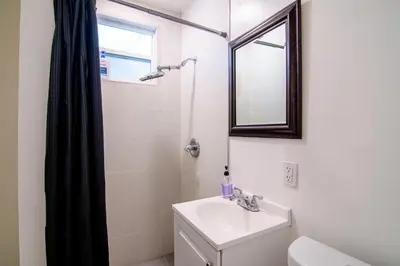 a white bathroom with a sink and a shower at Relaxing 1 Bedroom Suite Near Beverly Hills in Los Angeles