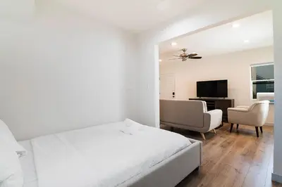 a white bedroom with a bed and a desk at Freshly Renovated Studio for Two in the Heart of LA in Los Angeles