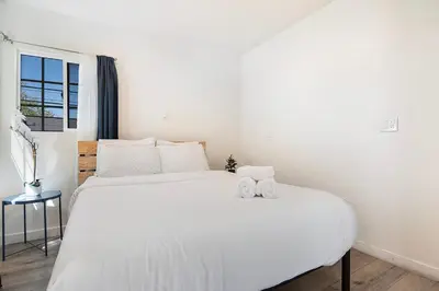 a bedroom with a white bed with two towels on it at Upper-Level Studio Suite Close to Beverly Hills in Los Angeles