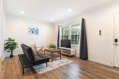 a living room with a couch and a television at Cozy Studio Suite Near Beverly Hills for Two in Los Angeles
