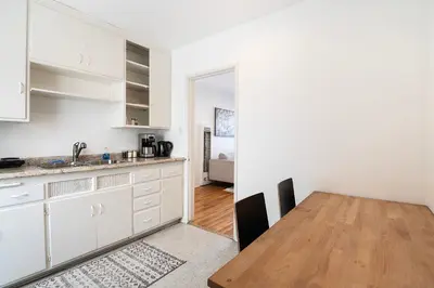a kitchen with white cabinets and a wooden table at Affordable One-Bedroom Close to Pico and Beverly Hills in Los Angeles