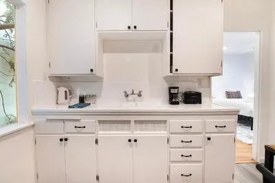 a kitchen with white cabinets and a sink at Bright Second-Floor Studio Near Beverly Hills in Los Angeles