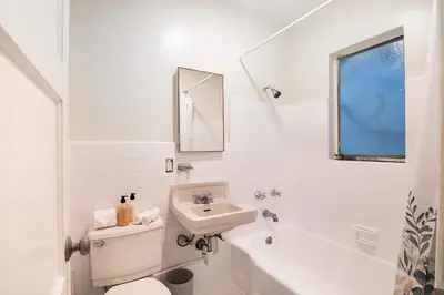 a white bathroom with a sink and a toilet at Bright Second-Floor Studio Near Beverly Hills in Los Angeles