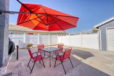 a table and chairs with a red umbrella on a patio at Southbaysunshine coastal Villa by beach-30 plus Days in Torrance