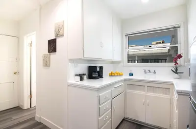 a white kitchen with a sink and a window at Comfortable 2Bedroom apartment close to Beverly Hills in Los Angeles