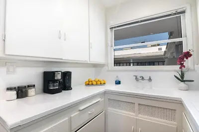 a white kitchen with a sink and a window at Comfortable 2Bedroom apartment close to Beverly Hills in Los Angeles