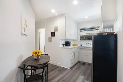 a kitchen with a table and a black refrigerator at Comfortable 2Bedroom apartment close to Beverly Hills in Los Angeles