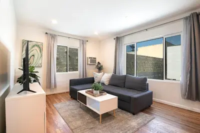 a living room with a couch and some windows at Comfortable One-Bedroom with Two Queen Beds in Los Angeles