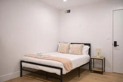 a bedroom with a bed with white walls at Calm Luxe Ensuite Room near USC-Shared Home in Los Angeles