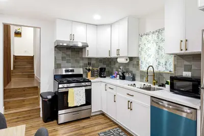 a kitchen with white cabinets and a stove top oven at Family Retreat Near Disneyland & Downtown LA 4BR in Los Angeles
