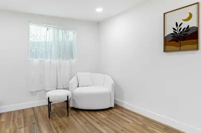 a white chair and stool in a room with a window at Family Retreat Near Disneyland & Downtown LA 4BR in Los Angeles