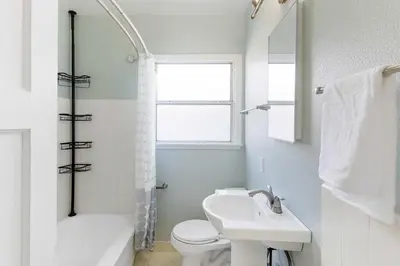 a bathroom with a sink and a toilet and a window at Family Oasis Near Disneyland & Knotts in Downey