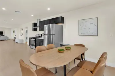 a kitchen and dining room with a wooden table and chairs at Stylish LA Retreat Near Disney Knotts SoFi in Paramount
