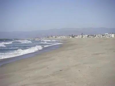 a sandy beach with houses in the background and the ocean at Luxe Beachside Escape Near Channel Islands in Oxnard